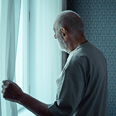 elderly man looking out window