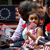 girl waves flag at naturalization ceremony
