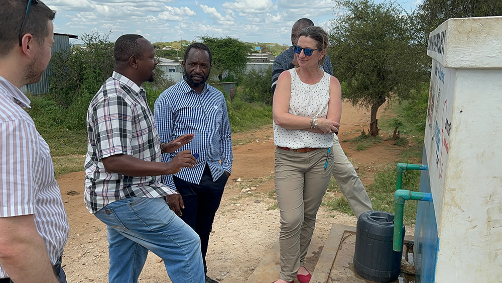 woman with a group of men near a water tank