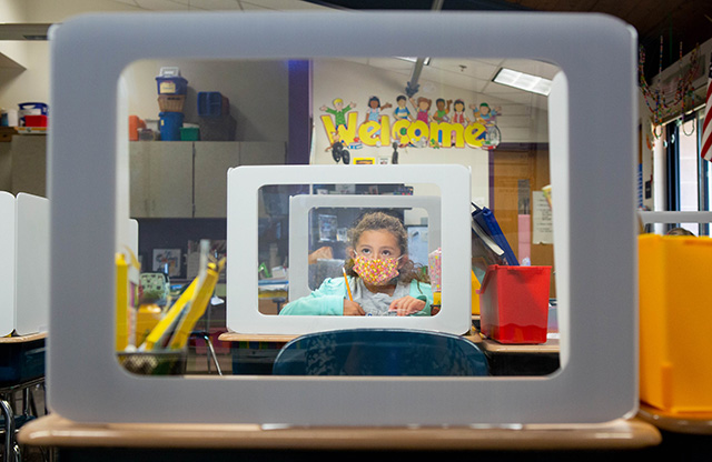 Girl wearing mask inside classroom