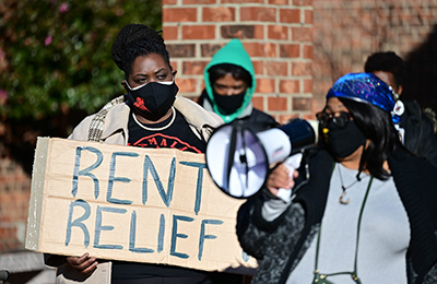 Woman holding rent relief sign at protest