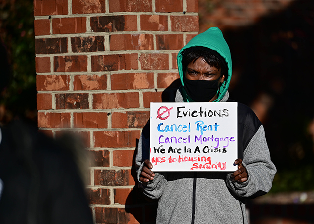 Woman holding sign at rent relief protest