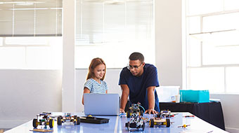 Girl and instructor work on a robotics project