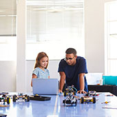 Girl and instructor work on a robotics project