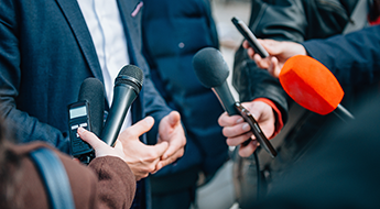 man being interviewed by reporters
