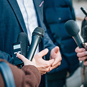 man being interviewed by reporters