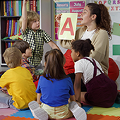teacher in classroom with pre-k students learning the alphabet