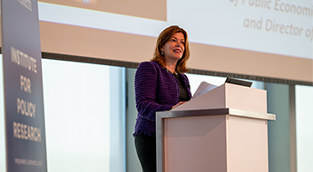 Diane Schanzenbach at podium introducing a speaker