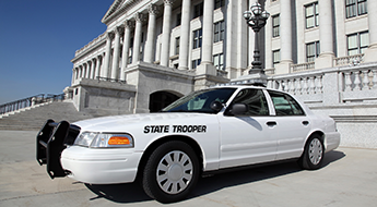 State trooper car parked outside of a government building.