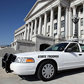 State trooper car parked outside of a government building.