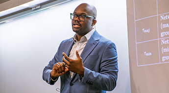 Chika Okafor presents his research on social network discrimination at an IPR colloquium on May 11.