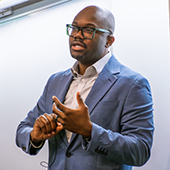 Chika Okafor presents his research on social network discrimination at an IPR colloquium on May 11.