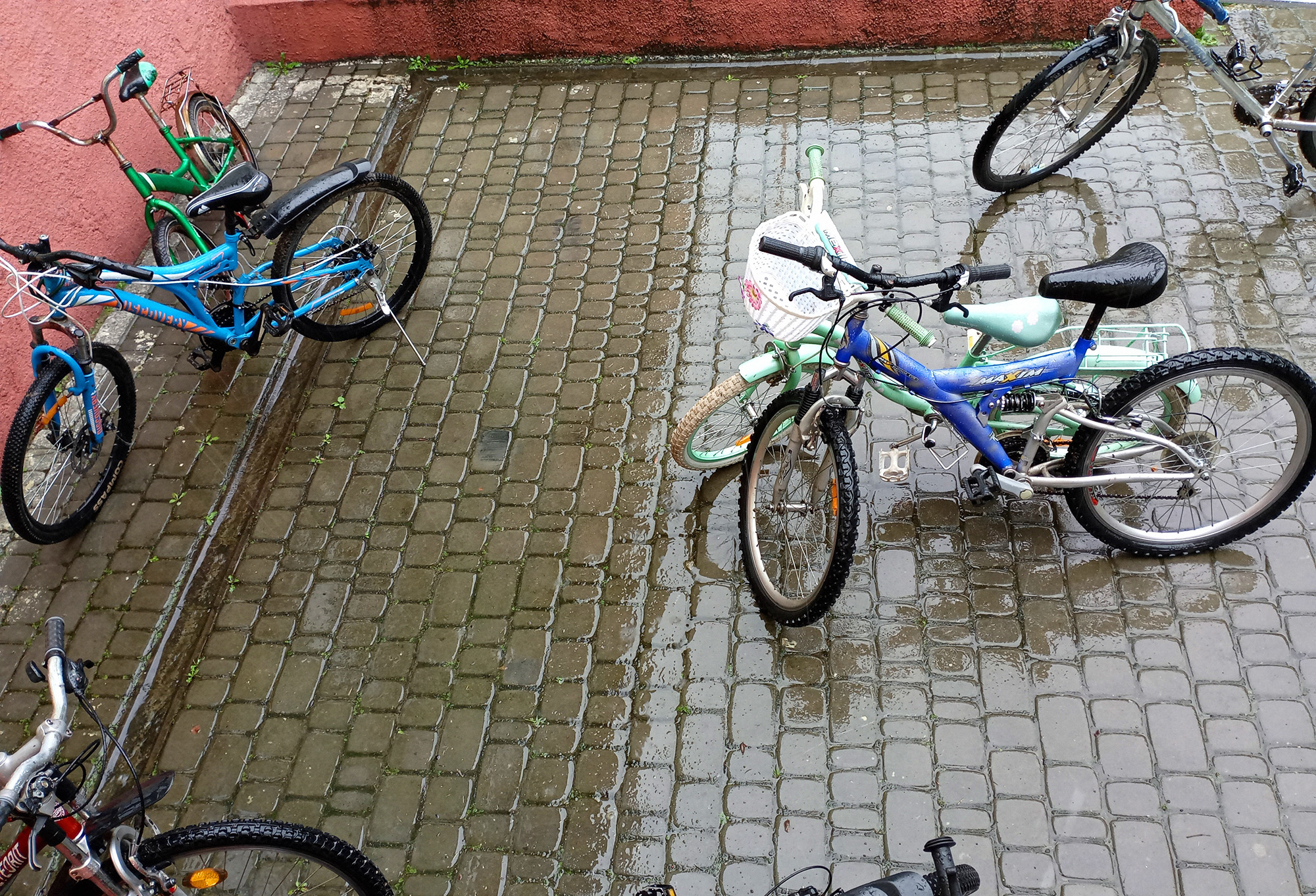 Bicycles stand on wet cobblestones in the rain in Kornalovichi village in western Ukraine.
